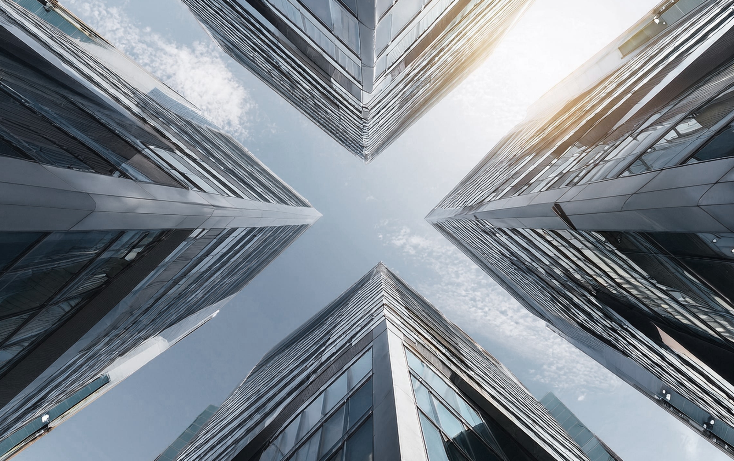 worm's-eye view of four modern buildings with glass fronts