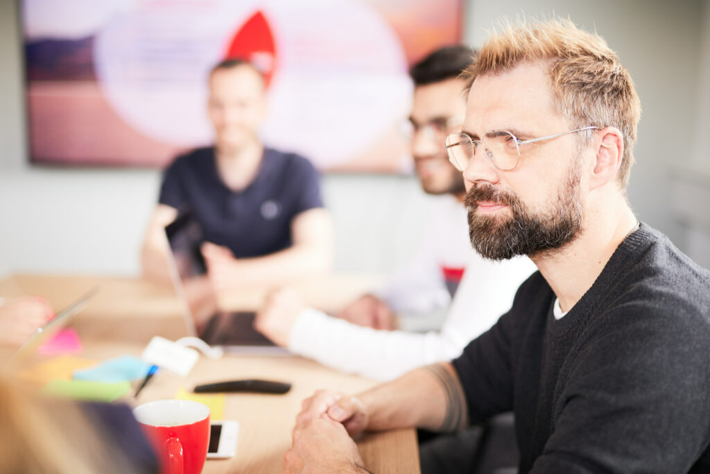 Close-up von einem Mann mit Brille in einem valantic CX-Meeting über Customer Experience.