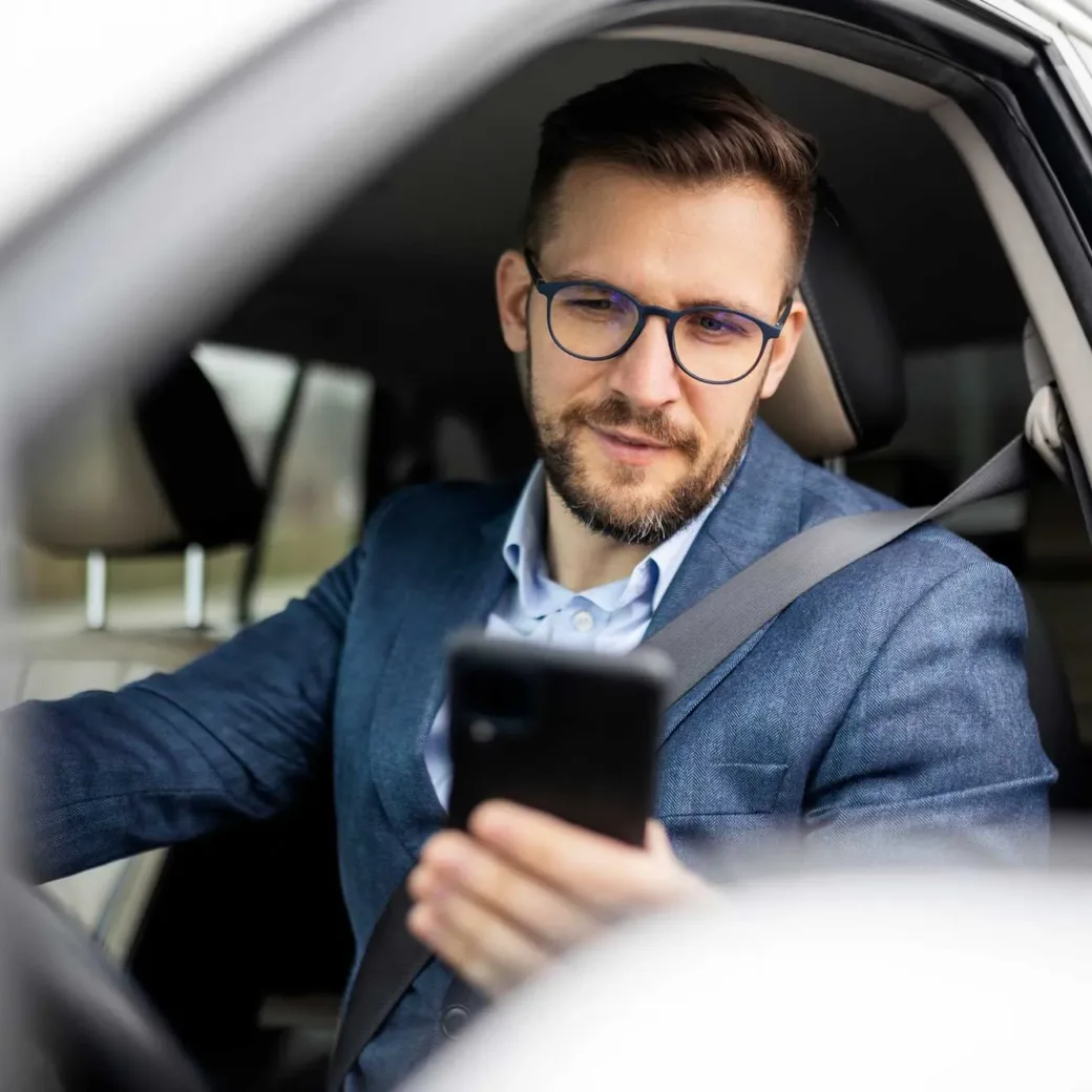 businessman texting and driving in his car