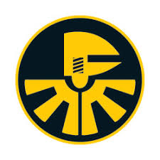 A circular emblem featuring a stylized yellow figure wearing a helmet, with radiating yellow lines at the bottom, on a dark background, reminiscent of imagery from the valantic Manufacturing Seminar.