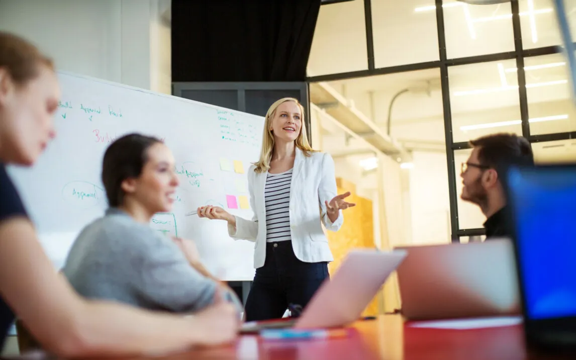 Young businesswoman giving presentation on future plans to her colleagues at office