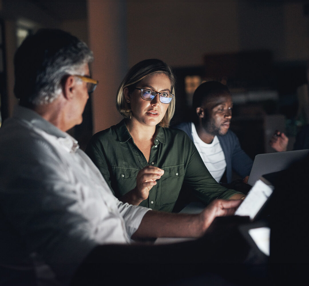 Shot of a group of colleagues having a meeting during a late night in a modern office