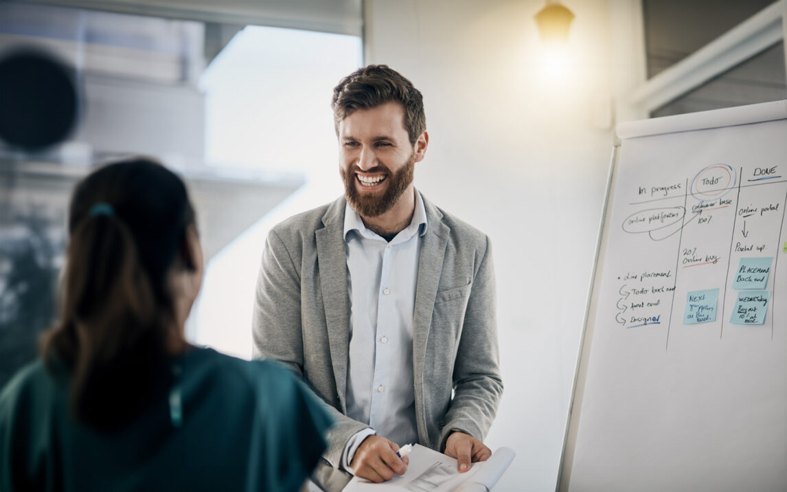 Shot of a young businessman using a whiteboard during a presentation in an office