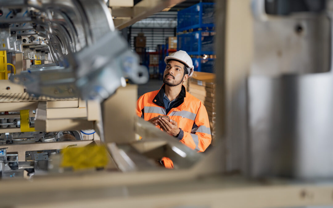 Young man industrial engineer wearing a white helmet while check the welding on the production line in the factory.