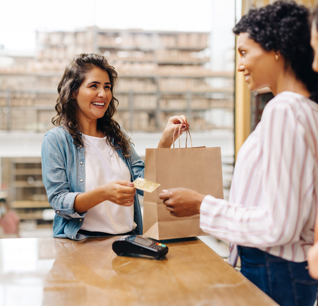 Cheerful young woman smiling happily while shopping from a local female-owned small business.