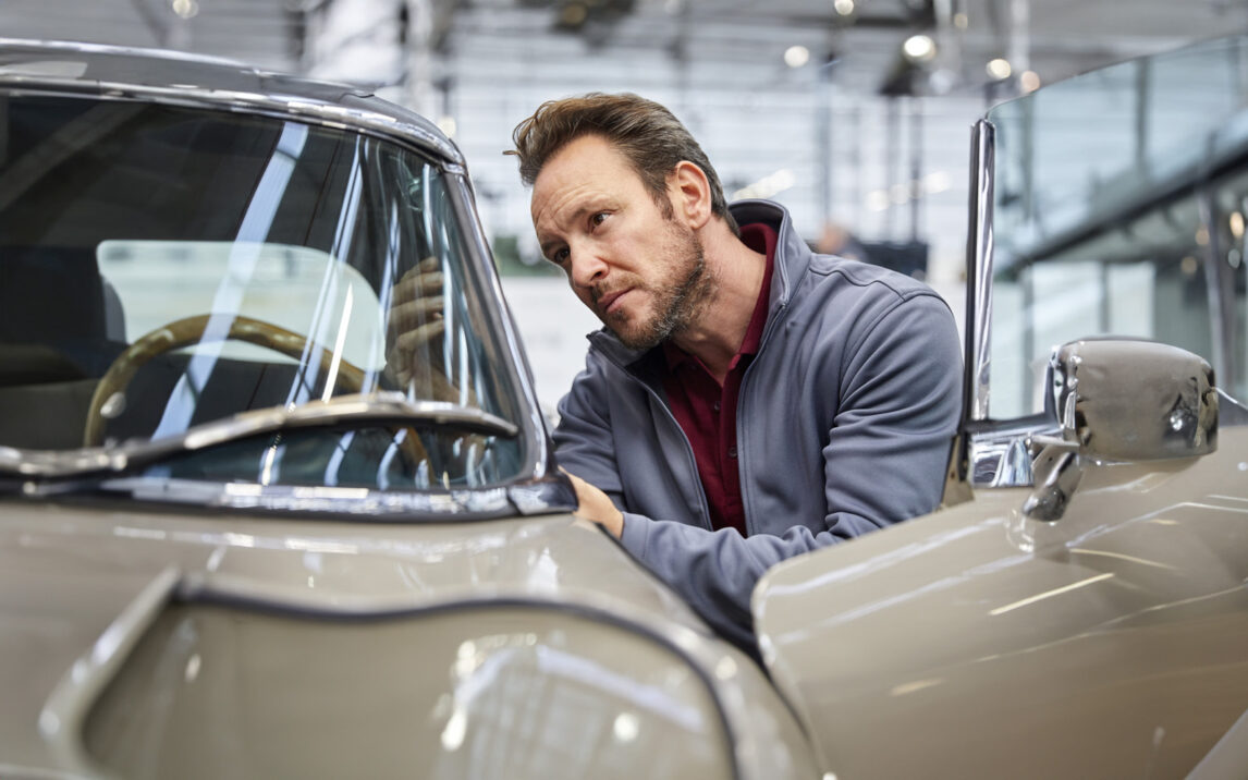 male engineer examining vintage car in industry