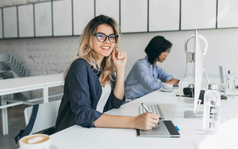 Smiling woman sitting at a desk | SAP Business Planning & Consolidation SAP BPC