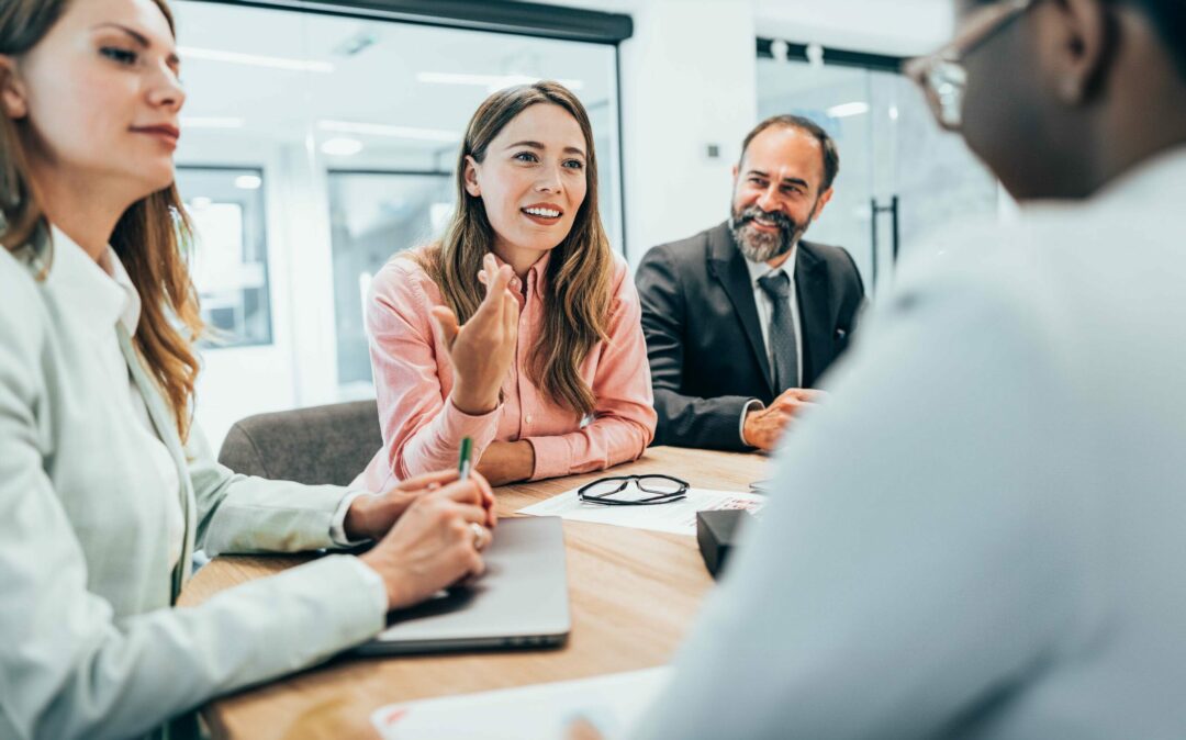 Modern business team discussing new ideas at the office. Business people on meeting in modern office. Colleagues smiling and talking at board room. Brainstorming