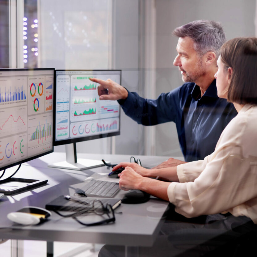 Woman and men are analyzing a dashboard on a monitor.