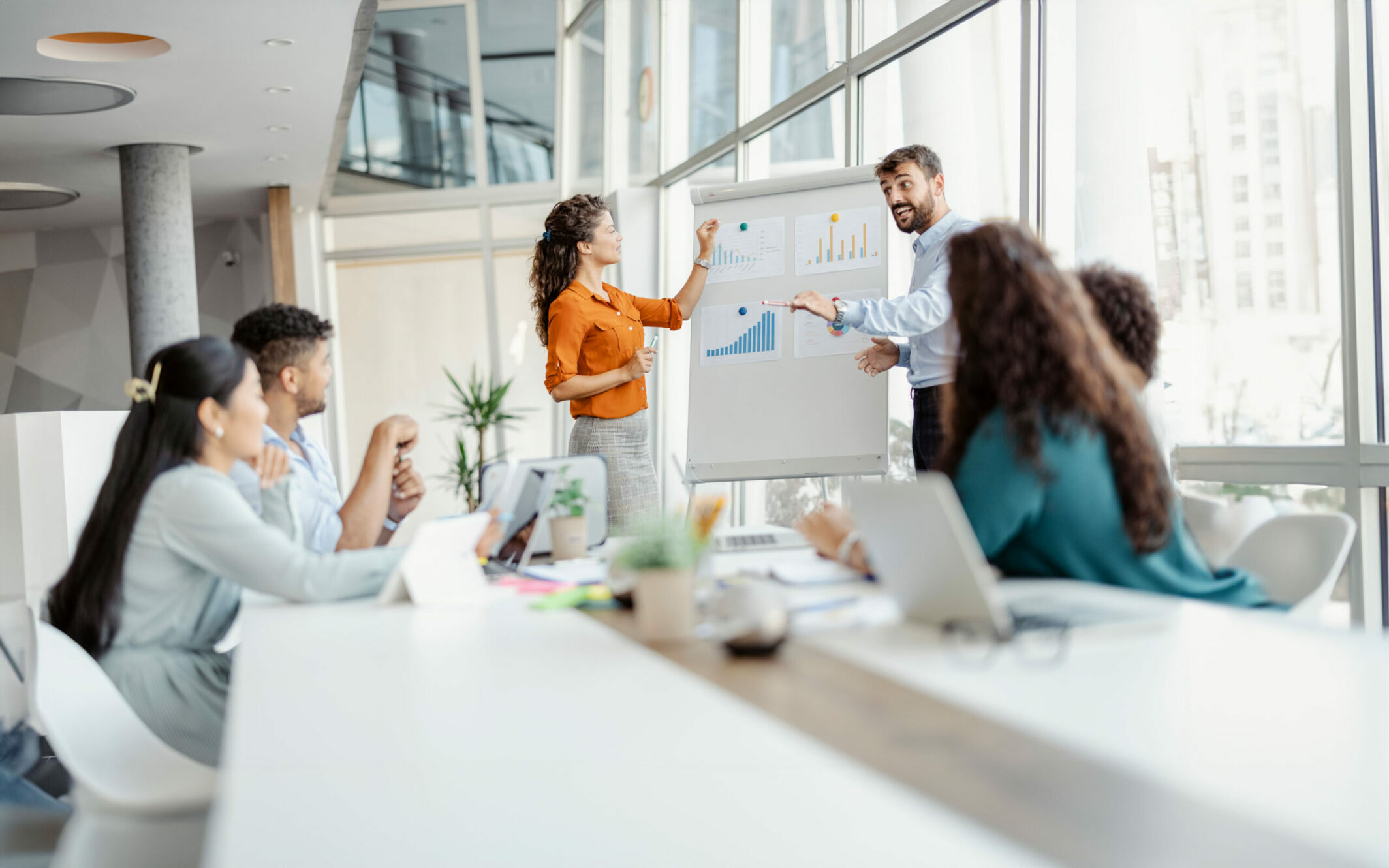 Business people talk about the business plan shown on the diagram on the board during a presentation in a pleasant atmosphere at the workplace.