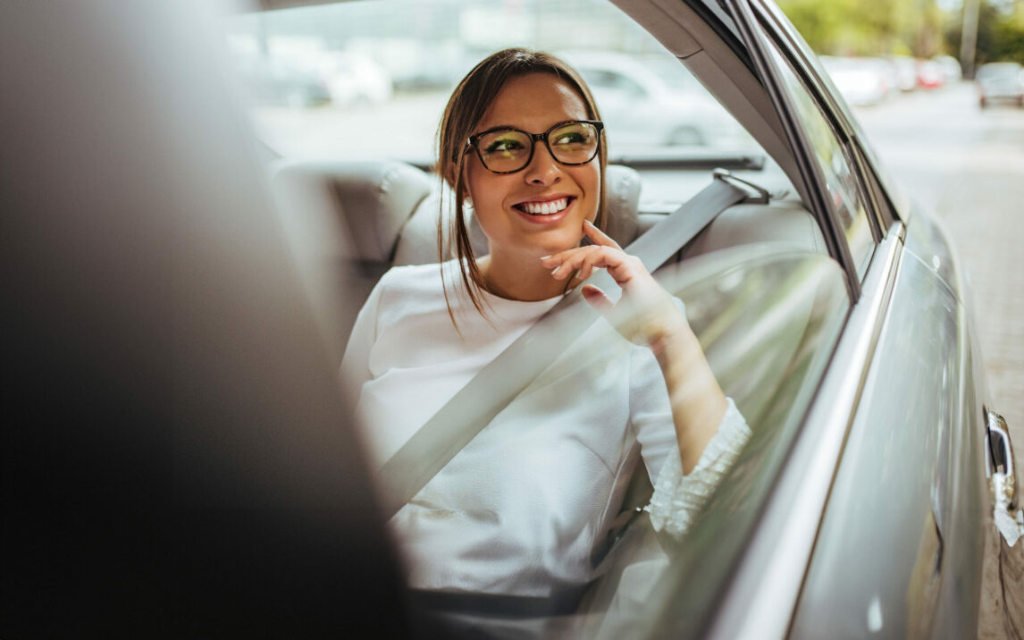 Portrait of a woman in back seat of car looking out of window