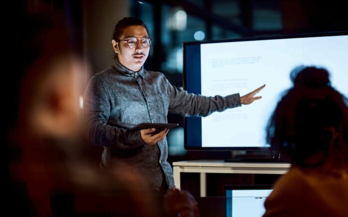 Shot of a young businessman delivering a presentation during a late night meeting at work