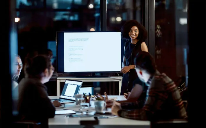 Shot of a young businesswoman delivering a presentation during a late night meeting at work