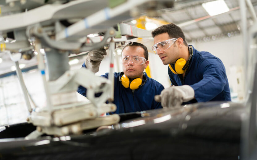 Mechanics fixing the roto of a helicopter