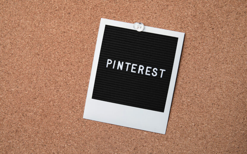 Abbildung: Schwarzes Polaroid-Foto mit der Aufschrift "PINTEREST" angepinnt auf einem Kork-Hintergrund
