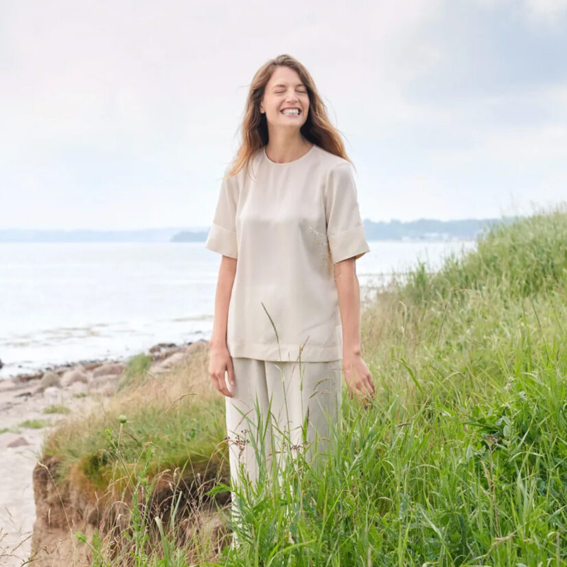 Foto von einer glücklichen Frau in den Dünen.