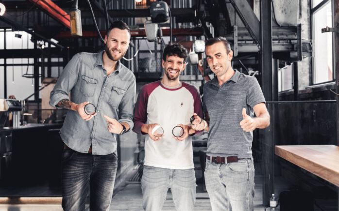 Drei Männer von valantic Austria halten ihre T.A.I.-Werbe-Grand-Prix-Auszeichnungen in die Kamera