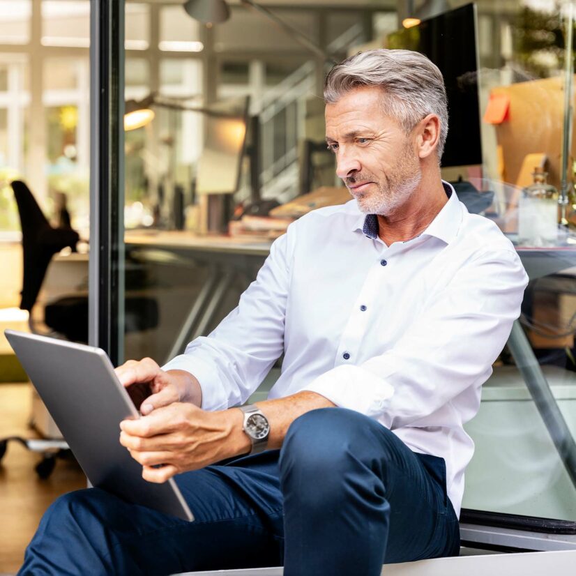 Businessman working on digital tablet while sitting