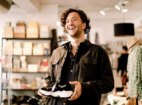 happy male customer smiling while buying shoes