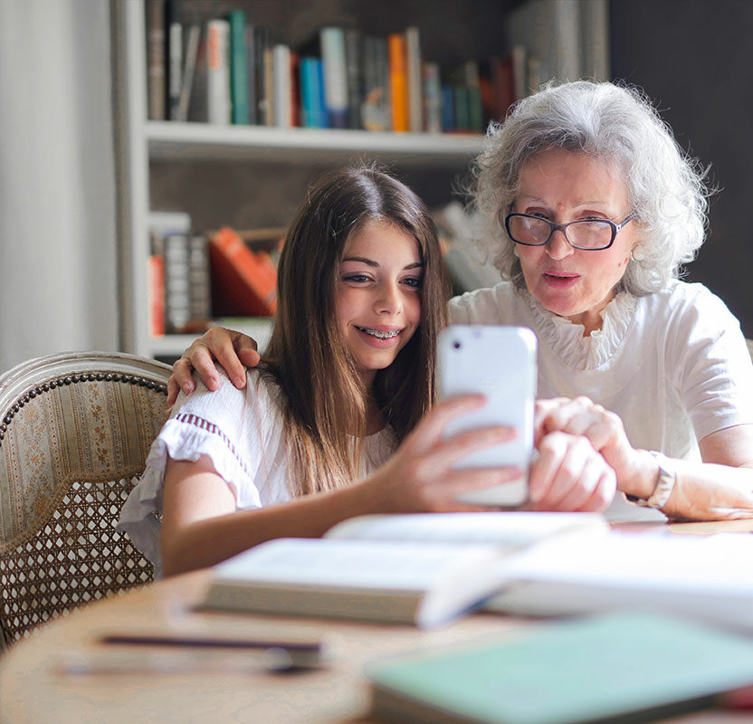 A granddaughter and grandmother are using an EAA-compliant platform or an accessible online shop on a smartphone.