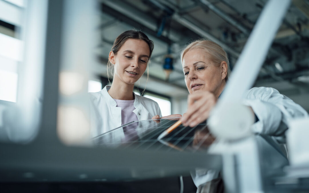 Smiling scientist with colleague discussing over solar panel