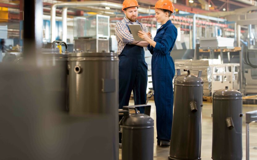 2 people in a warehouse environment discussing maintenance