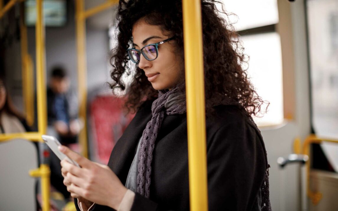 young woman traveling by bus and using smart phone