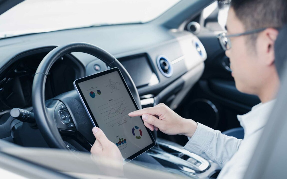 side view of a young business man using ipad whilesitting in car