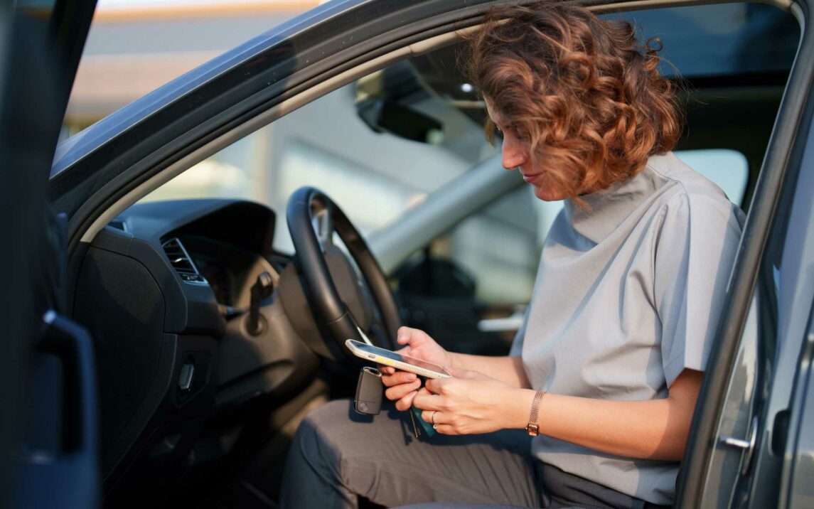 healthcare workers using mobile phone in her car