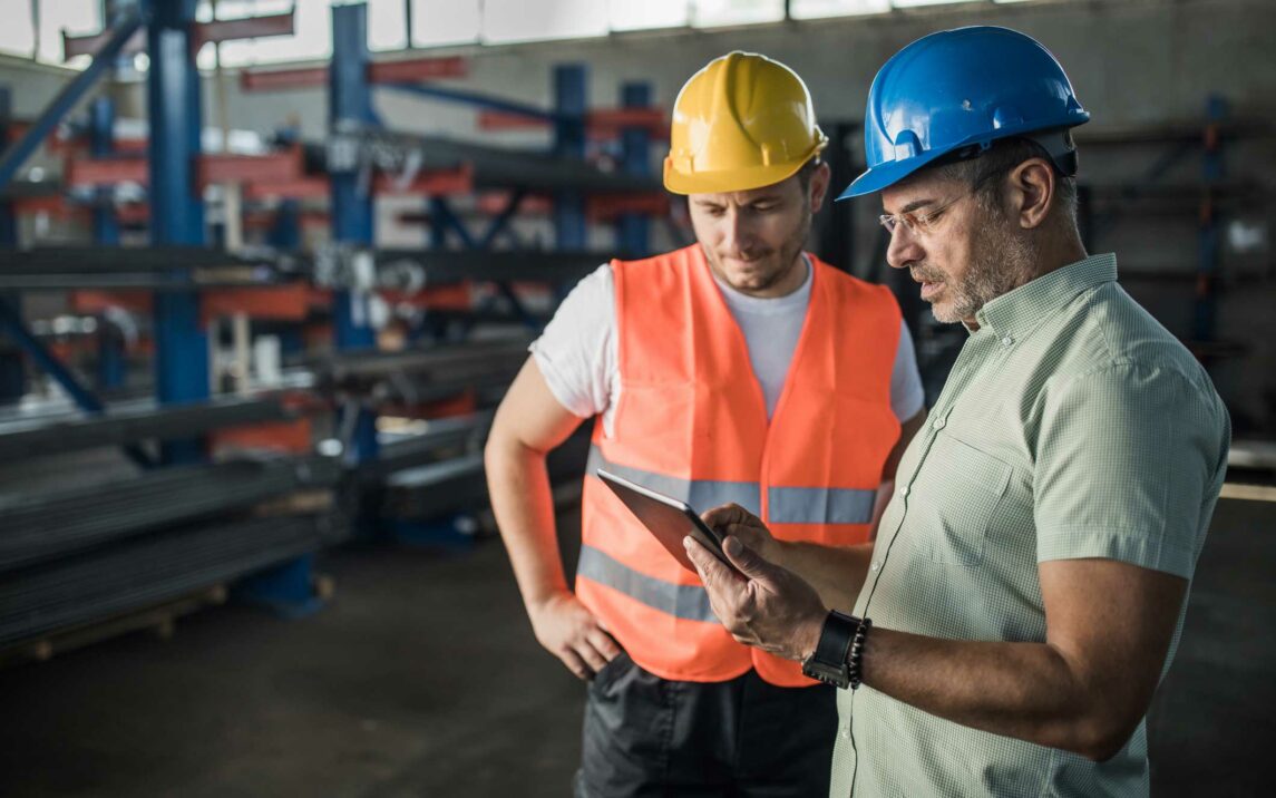 inspector and metal worker analyzing work plan