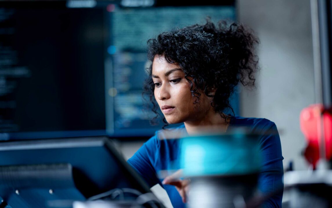 female software developer coding on a computer