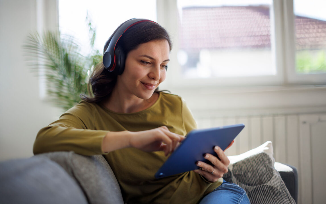 Woman resting on couch and using digital tablet