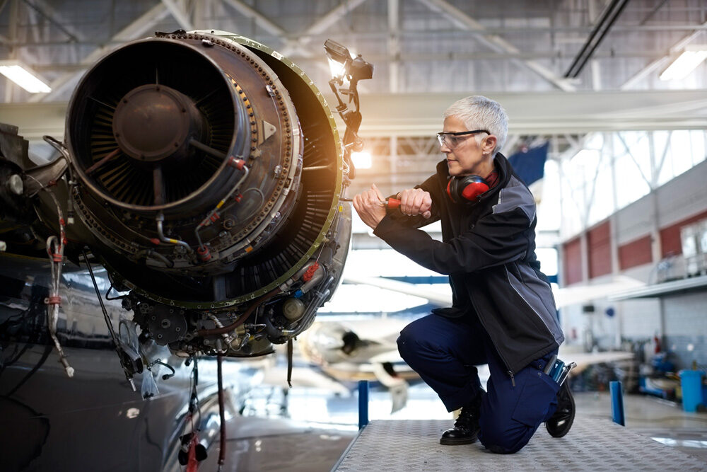 Fluggerätmechaniker im Hangar, arbeitet am Flugzeug