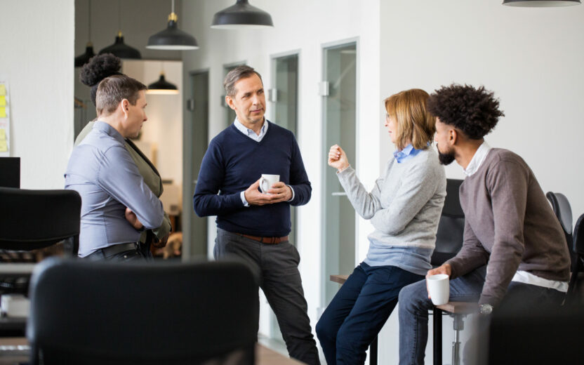 Group of businesspeople talking during a coffee break. Office workers having a casual talk during coffee break.