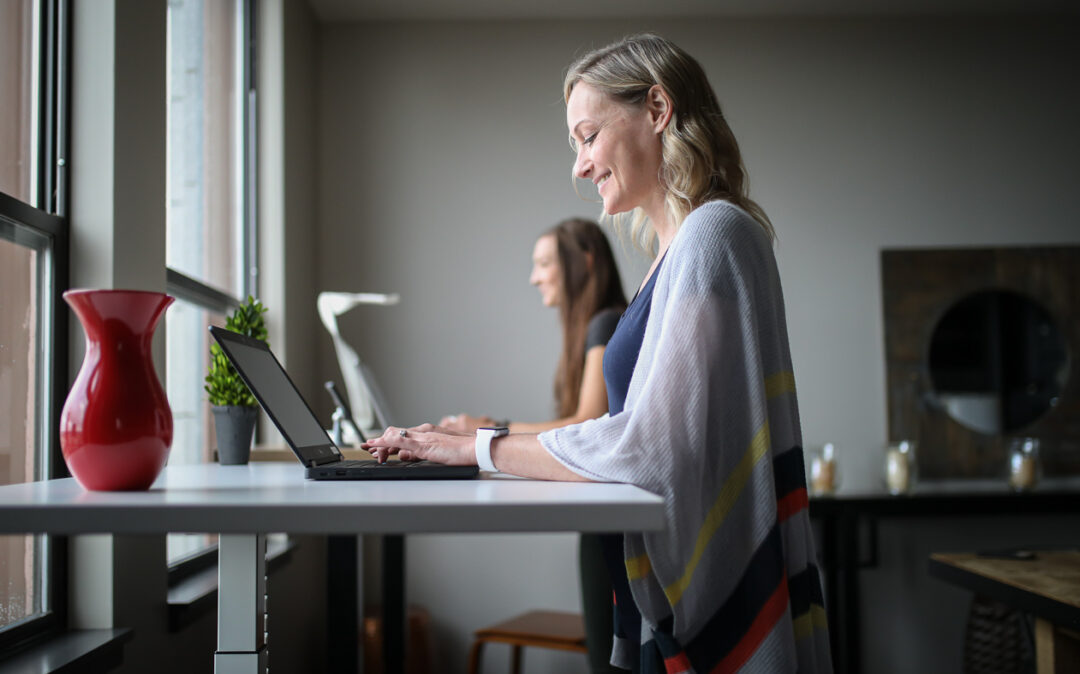 Picture of two women working at standing desks.