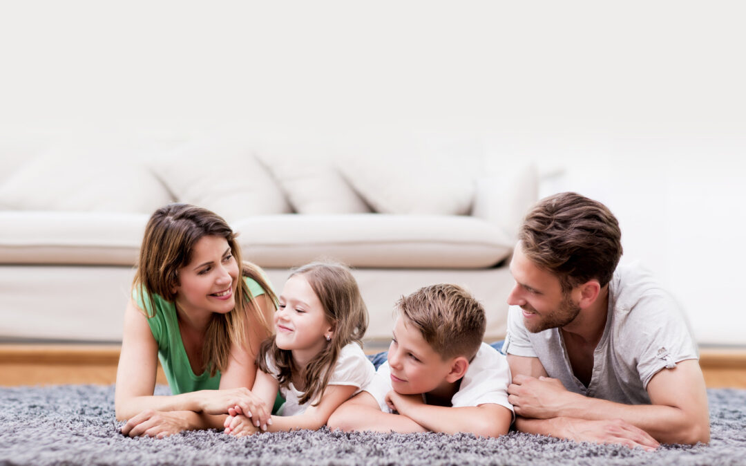 Image of a couple and their two children on a fluffy carpet.