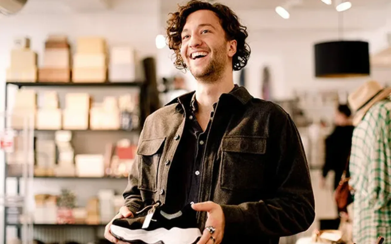 happy male customer smiling while buying shoes