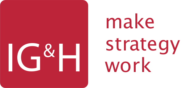 Logo of IG&H featuring a red square with the letters "IG&H" in white on the left and the text "make strategy work" in red on the right, showcased at the OutSystems NextStep Experience.