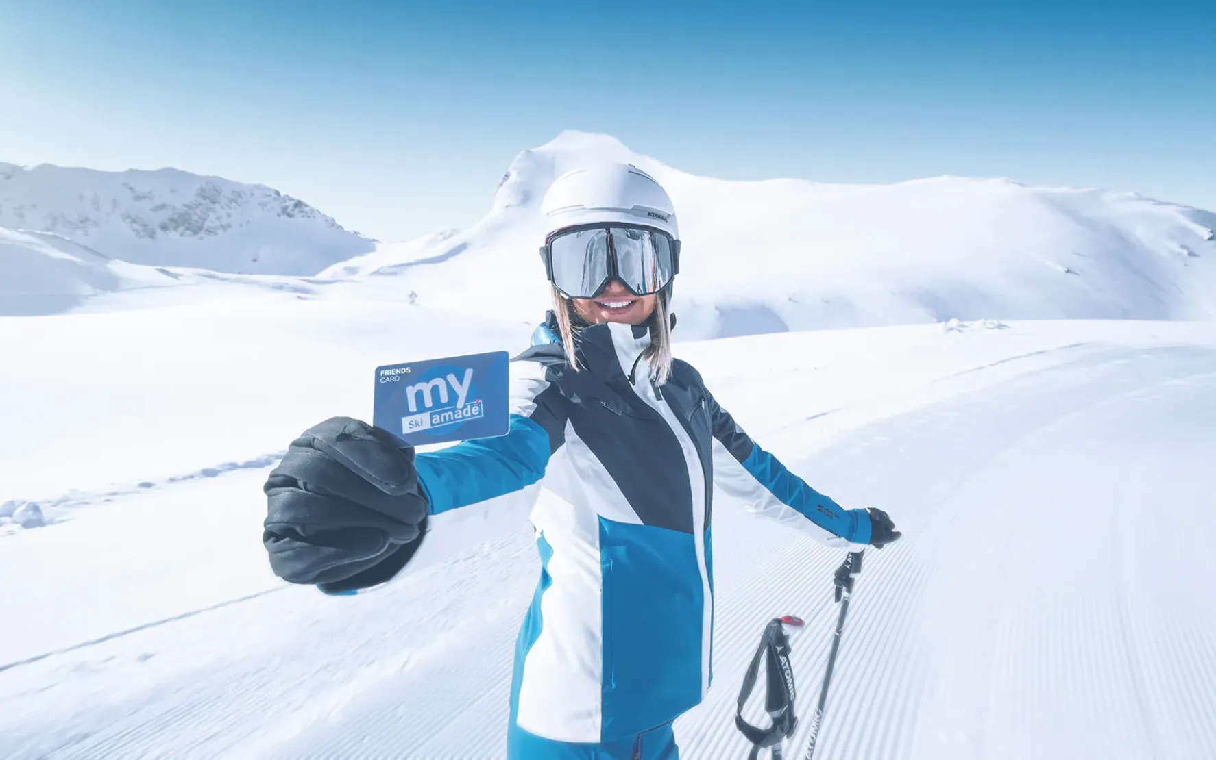Junge Frau im Skianzug, mit Skihelm und Skibrille hält eine Ski amadé Vorteilsclub-Mitgliedskarte in die Kamera