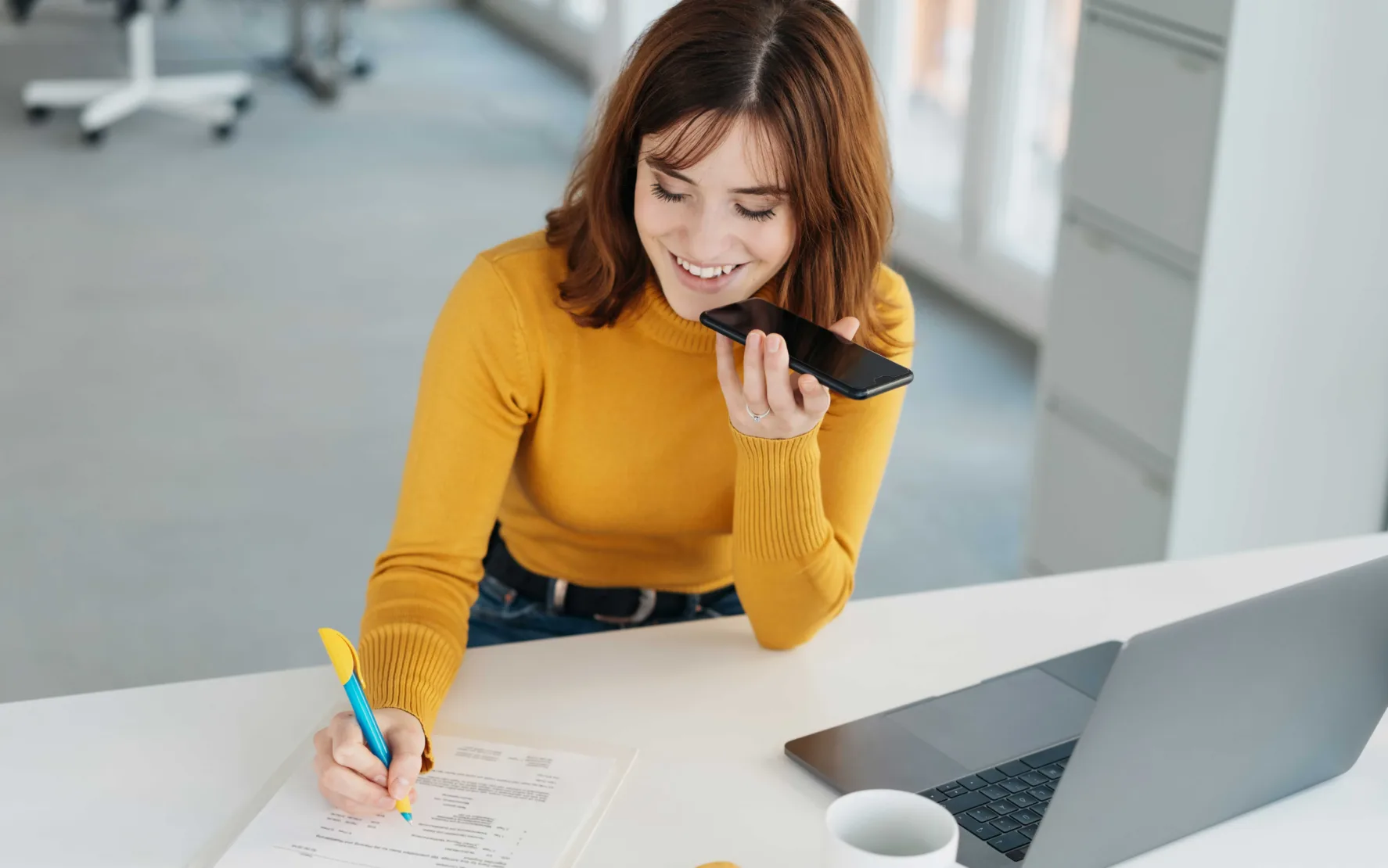 Frau, die telefonierend am Schreibtisch sitzt - Microsoft Azure - Microsoft Power BI